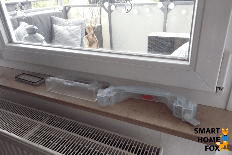 Staubbehälter eines Saugroboters wird nach dem Waschen auf der Fensterbank getrocknet